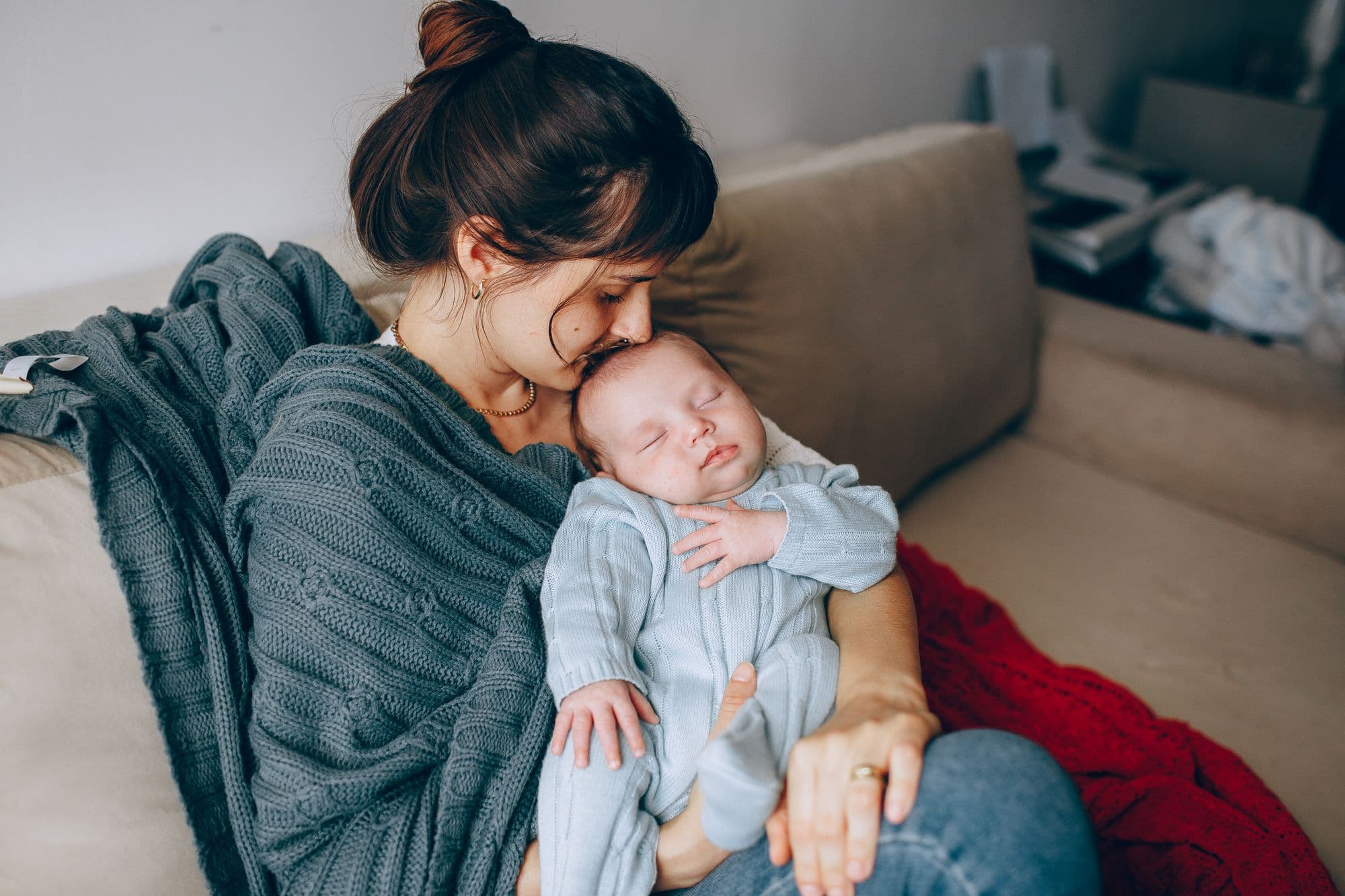 Mãe acolhendo seu bebê em um momento de carinho em casa